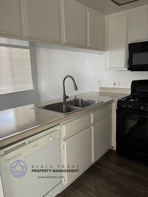 a kitchen with white cabinets and a sink